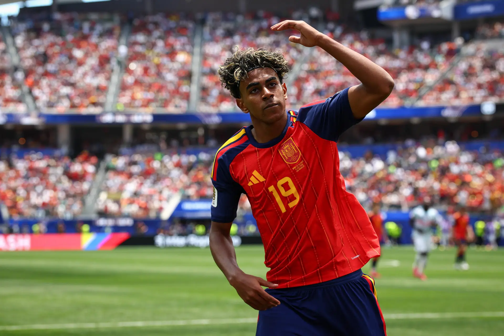 Jogador com a camisa vermelha número 19 da seleção da Espanha num estádio cheio